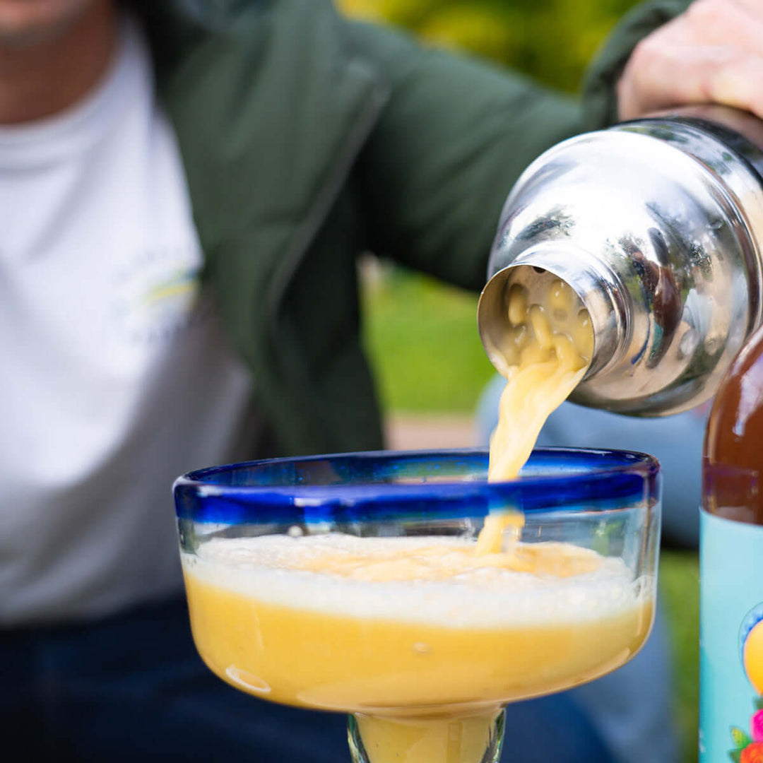 Pouring mango and passionfruit margarita form the mixer